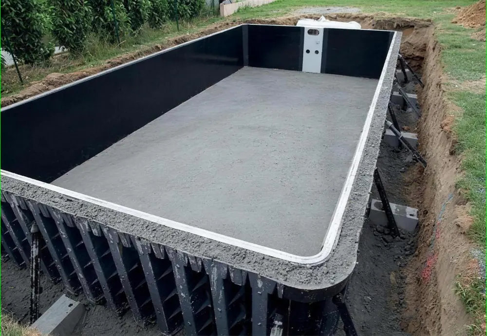 Structure Desjoyaux en cours de chantier : panneaux de coffrage, radier béton et bloc de filtration en place