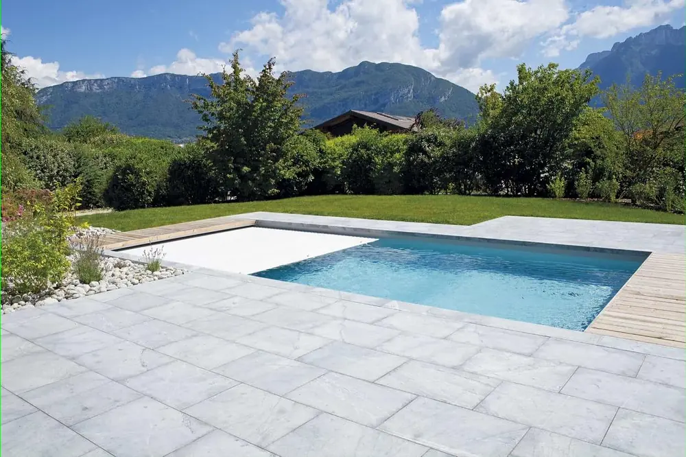 Piscine Desjoyaux équipée d'un volet de sécurité immergé, terrasse dallée